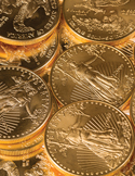 A close-up, overhead view of a pile of shiny gold coins.