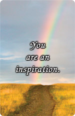 Rainbow over a grassy path under a cloudy sky with the message “You are an inspiration.”
