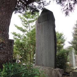 Usui memorial engraved with Japanese text, surrounded by trees and greenery in a peaceful outdoor setting