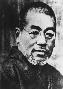 Black-and-white portrait of Usui-Sensei with glasses, short hair, and a trimmed beard, wearing traditional clothing.