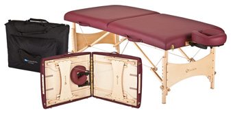 Portable massage table in burgundy with wooden legs, shown folded open with accessories stored inside and a carrying case beside it.